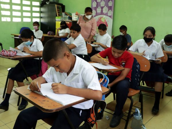 Una docente imparte clases a niños de primaria en una escuela de Panamá